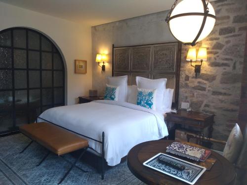 a hotel room with a bed, table, lamp and a window at Banyan Tree Puebla in Puebla