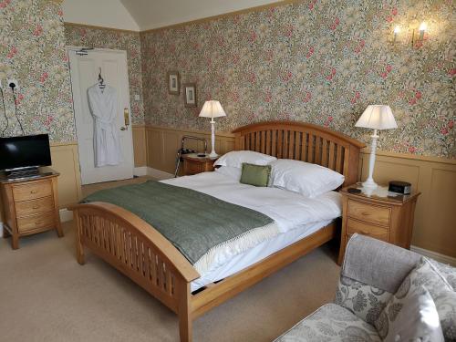 a bedroom with a bed and a suit on the wall at Greycroft B&B in Alnwick