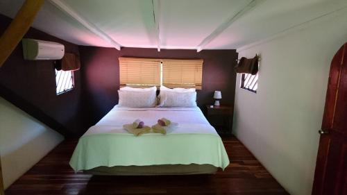 a bedroom with a bed with two teddy bears on it at Casa Verde, Cahuita in Cahuita