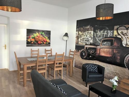 ein Esszimmer mit einem Tisch und einem Gemälde eines Trucks in der Unterkunft Arbio Apartments near Yppenplatz & Brunnenmarkt in Wien