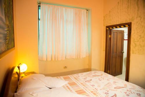 a small bedroom with a bed and a window at Posada Tambuca in Quito