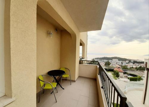 a balcony with chairs and a table and a view at Apartments Akmadzic in Makarska