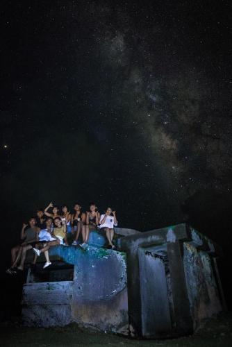 a group of people sitting on a wall at night at Good hostel 好棧 Green Island in Green Island