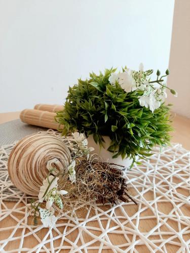 a table with a vase and flowers on it at Apartments Akmadzic in Makarska