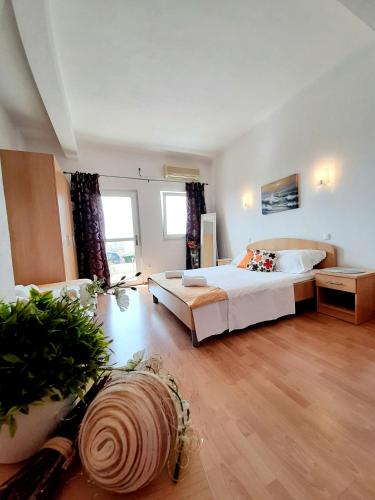 a large bedroom with a bed and a large window at Apartments Akmadzic in Makarska
