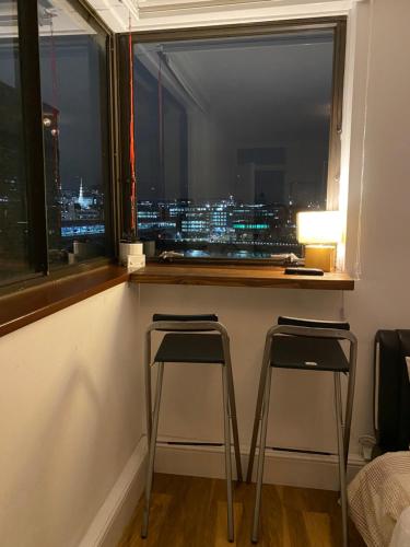 a view of a city from a window with two stools at Room in Central London Overview Thames in London