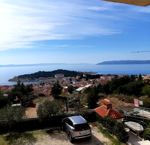 una furgoneta estacionada en un estacionamiento cerca del océano en Apartments Akmadzic, en Makarska