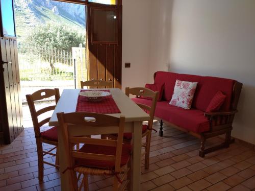 カステッルッツォにあるTerrazza sul Golfo di Castelluzzoのリビングルーム(テーブル、赤いソファ付)