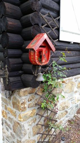 a red bird house on the side of a wall at Le chalet de Roanne-Coo in Stoumont