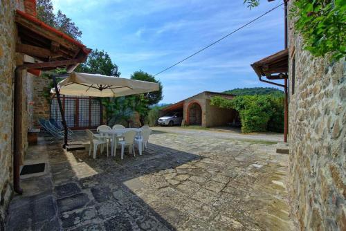 a patio with a table and chairs and an umbrella at Agriturismo Fattoria Celle in Figline Valdarno