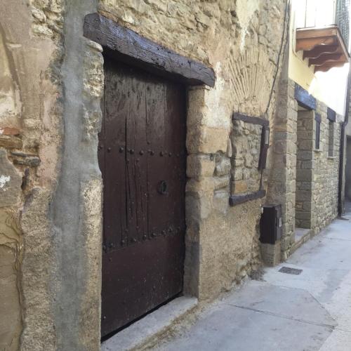 a brown door on the side of a stone building at Casa Carbonero in Lascuarre