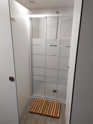 a walk in shower with a wooden mat in a bathroom at Camiño da Vieira in Padrón