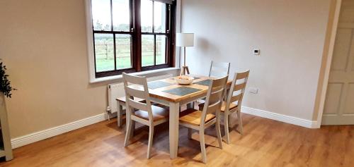 a dining room with a table and chairs and a window at Riverside Marina Apartments in Lanesborough