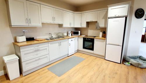 a kitchen with white cabinets and a white refrigerator at Riverside Marina Apartments in Lanesborough