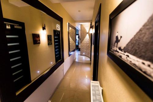 a hallway with paintings on the wall and a bench at Pensiunea Bradului in Colibiţa
