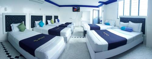a room with four beds with blue and white at Hotel Luna Azul in Florencia