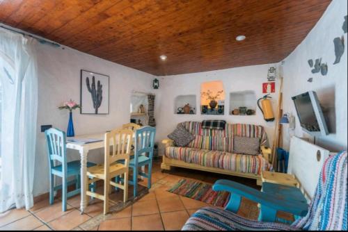 un soggiorno con tavolo e divano di Silence's Cave Rural House ad Artenara