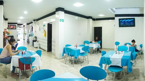 a restaurant with blue tables and chairs at Hotel Luna Azul in Florencia