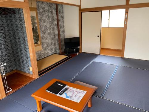 an empty room with a table and a room with a door at Onsen & Garden -Asante Inn- in Hakone