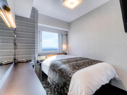 Postel nebo postele na pokoji v ubytování APA Hotel Takaoka Ekimae