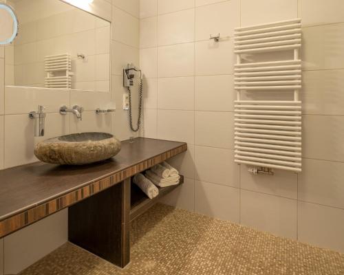 baño con lavabo de piedra y teléfono en Hotel und Restaurant Zum Deutschen Hause en Lübbenau