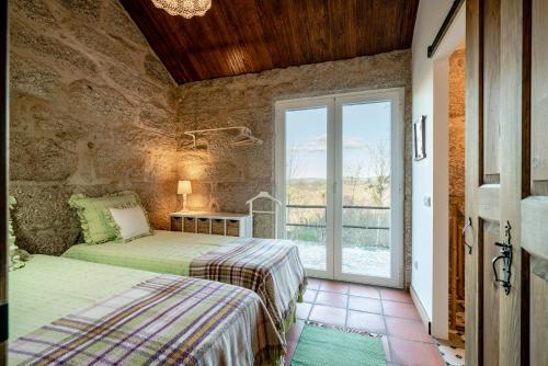 沃澤拉的住宿－Quinta das Lamas - Oak Tree House，一间卧室设有两张床和大窗户