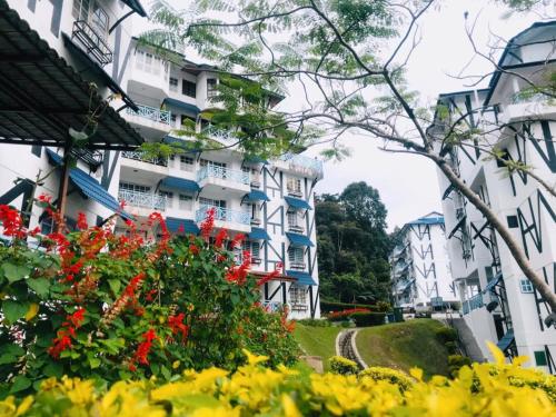 a group of buildings with flowers in front of them at MERLIN HOME DESA ANTHURIUM in Tanah Rata