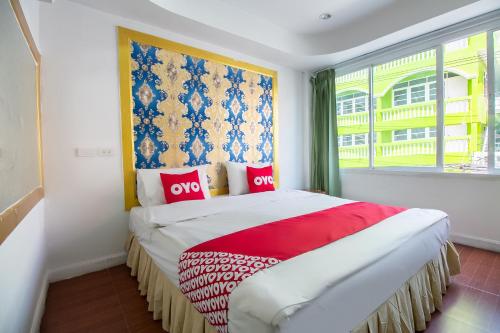 曼谷的住宿－OYO 410 Diamond Boutique Hostel，一间卧室配有一张带红色枕头的床和一扇窗户