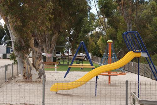 a playground with a yellow slide in a park at Ardrossan Caravan Park in Ardrossan