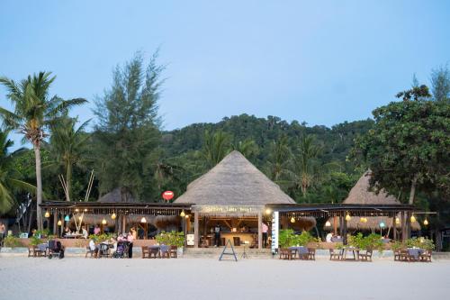 a resort on the beach with tables and chairs at Southern Lanta Resort - SHA Extra Plus in Ko Lanta