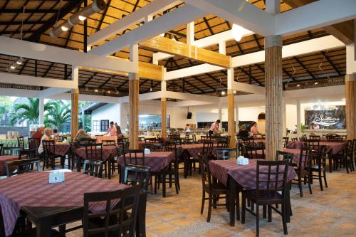 a restaurant with tables and chairs and people in the background at Southern Lanta Resort - SHA Extra Plus in Ko Lanta