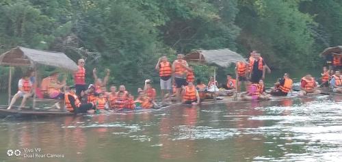 un groupe de personnes portant des gilets de sauvetage orange dans l'eau dans l'établissement Star Hill River Kwai Resort, à Ban Kaeng Raboet
