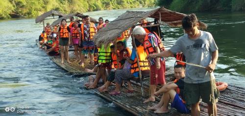 un groupe de personnes sur un radeau sur une rivière dans l'établissement Star Hill River Kwai Resort, à Ban Kaeng Raboet