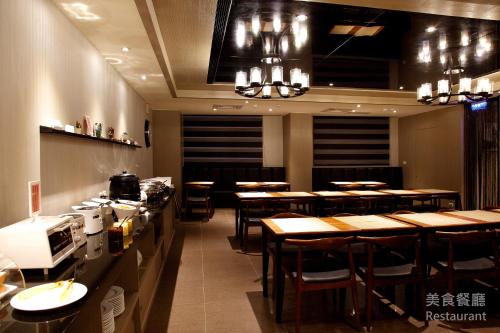 un restaurante con mesas de madera y sillas en una habitación en Grace Hotel en Taipéi