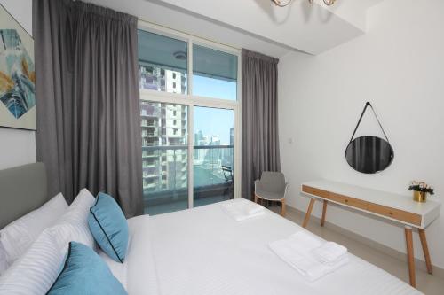 a bedroom with a bed and a desk and a window at SHH - Luxury 1 BR with Balcony, Marina view, Continental Tower, Dubai Marina in Dubai