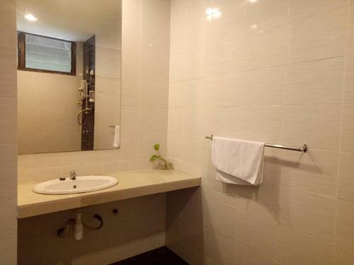 a white bathroom with a sink and a mirror at Motel Desa in Kuala Terengganu