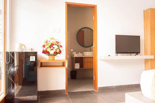 salon z telewizorem i lustrem w obiekcie Apple Villa & Suite Seminyak w mieście Seminyak