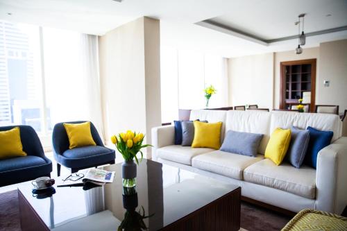 a living room with a white couch and blue and yellow pillows at voco Dubai by IHG in Dubai