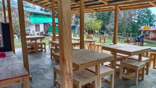 a group of tables and benches in a pavilion at Himtrek Stays,Mcleodganj in McLeod Ganj