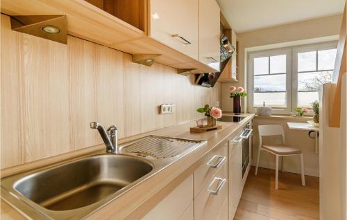 una cocina con fregadero de acero inoxidable y armarios de madera en Lovely Apartment In Langenhorn With House A Panoramic View, en Langenhorn