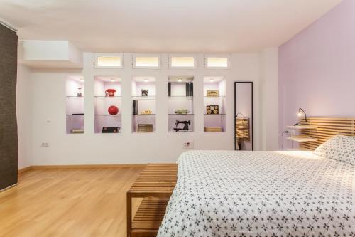 biała sypialnia z łóżkiem i półkami w obiekcie LF PARKING INCLUIDO Amplio Loft en Barrio Santa Cruz w Sewilli