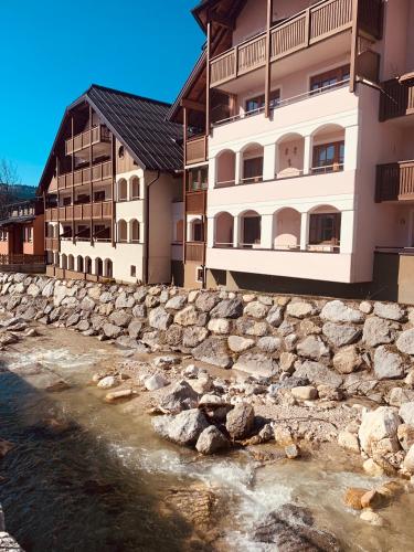a stone wall next to two buildings and a river at Dachstein in Russbach am Pass Gschütt