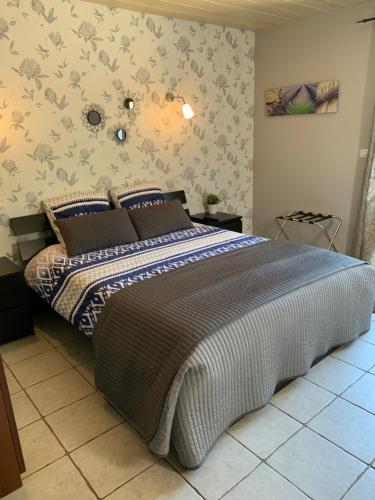 um quarto com uma cama com um edredão azul e branco em B&B La Grande Dame em Valensole