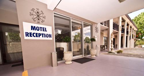 a motel reception sign on the side of a building at Bella Vista Motel in Gosford