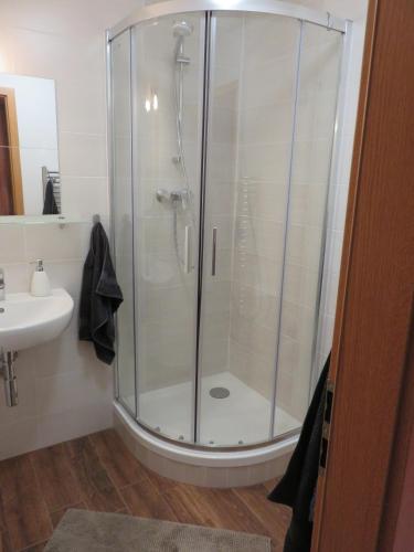 a shower with a glass door in a bathroom at MyMara , Apartmán Ivadella in Bešeňová