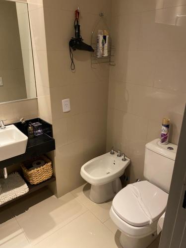 a bathroom with a white toilet and a sink at Palermo Soho Apartment Guemes in Buenos Aires