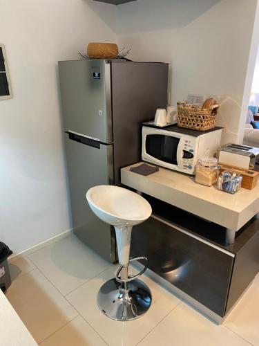 a kitchen with a counter with a microwave and a stool at Palermo Soho Apartment Guemes in Buenos Aires