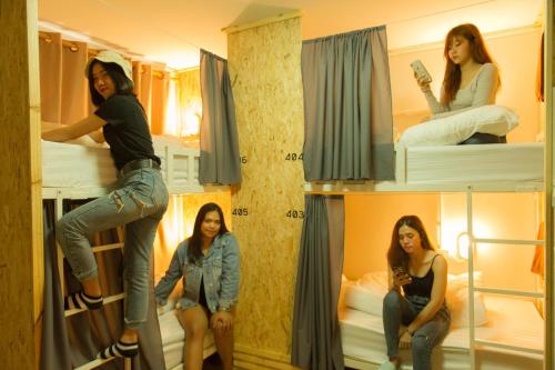 a group of girls sitting on a bunk bed at Khoksametchun Hostel in Hat Yai