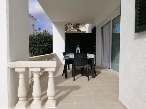 a balcony with a table and chairs on a house at VILLA DIPLOMADO (RELAX EN EL PARAISO) in Es Mercadal
