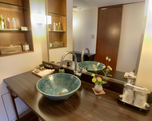 a bathroom with two sinks on a wooden counter at Komatsu-kan Kofu-tei in Matsushima